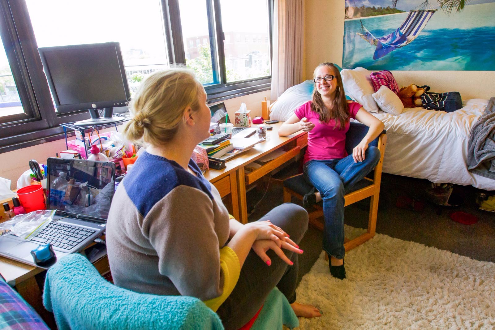 Two students talking in a dorm room.